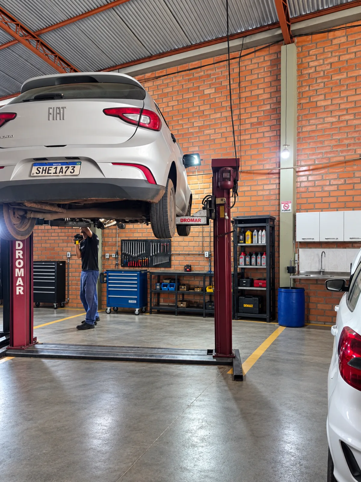 Mecânico da Rotta Automotiva trabalhando em carro no elevador